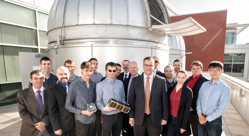 Federal Industry Minister James Moore (red tie) stands with the AlbertaSat student team outside the university's astronomical observatory April 13. Photo: Richard Siemens. 